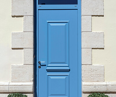 Porte d'entrée bleu sur façade grise