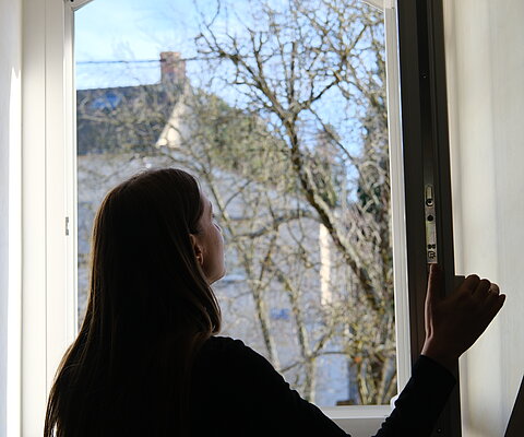 femme ouvrant la fenêtre