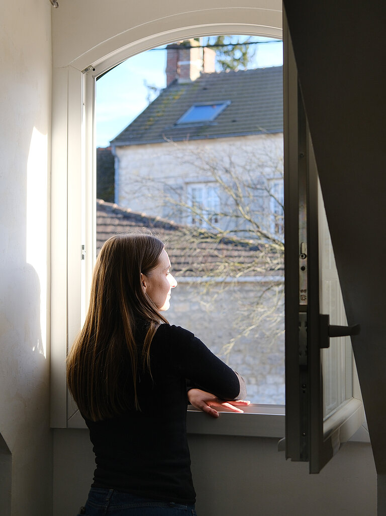 femme regardant par la fenêtre